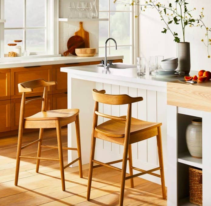 Two wood barstools by a white kitchen island.