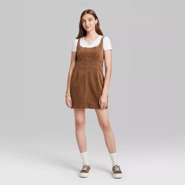 Model wearing caramel colored dress with circular neckline, stops at the thigh