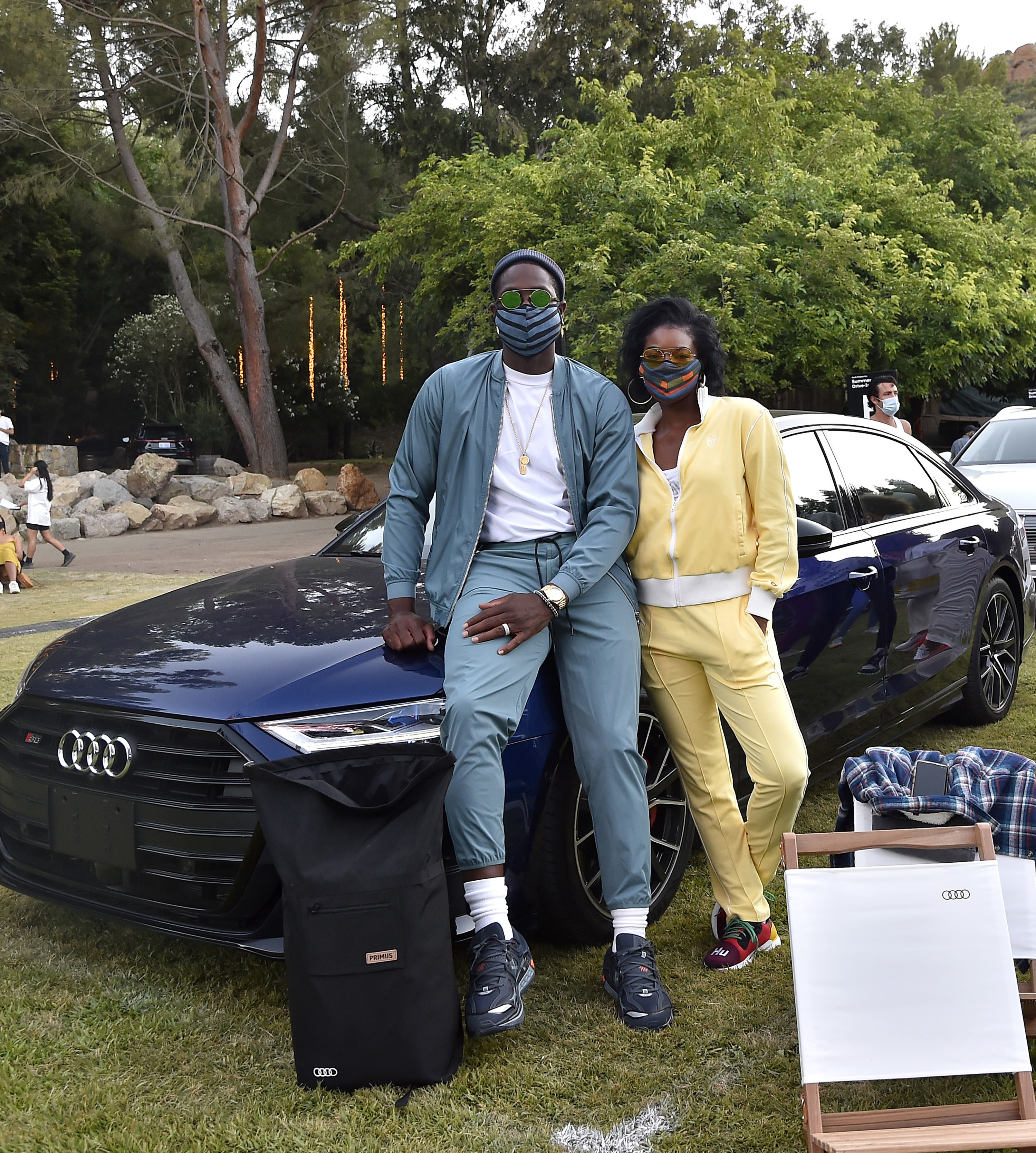 Gabrielle and her husband Dwyane leaning against a car and wearing face masks as they pose for a photo