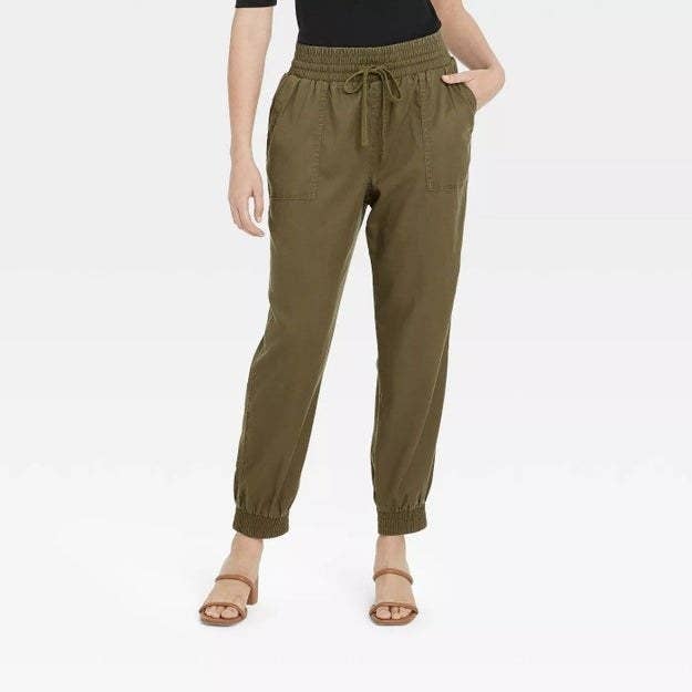 Model wearing green pants with side pockets and tie string detail around waist