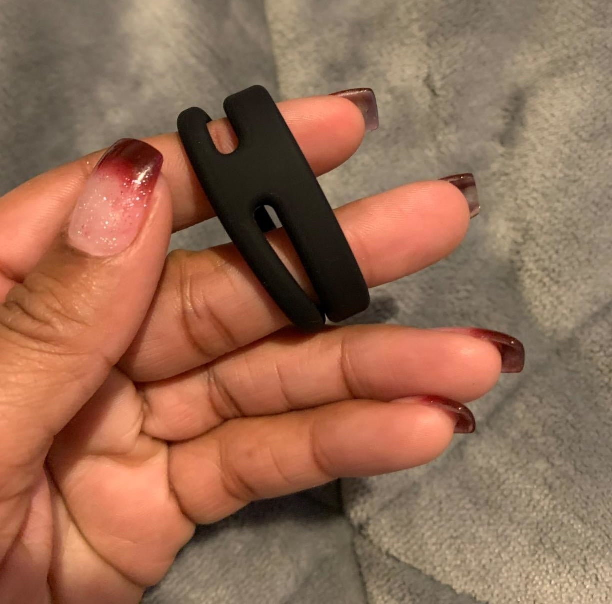 reviewer holding black dual cock ring
