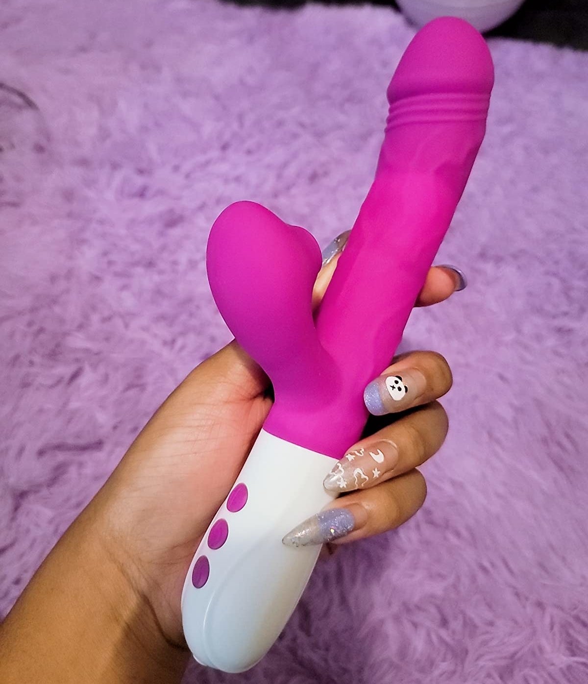 reviewer holding pink rabbit vibrator with suction arm