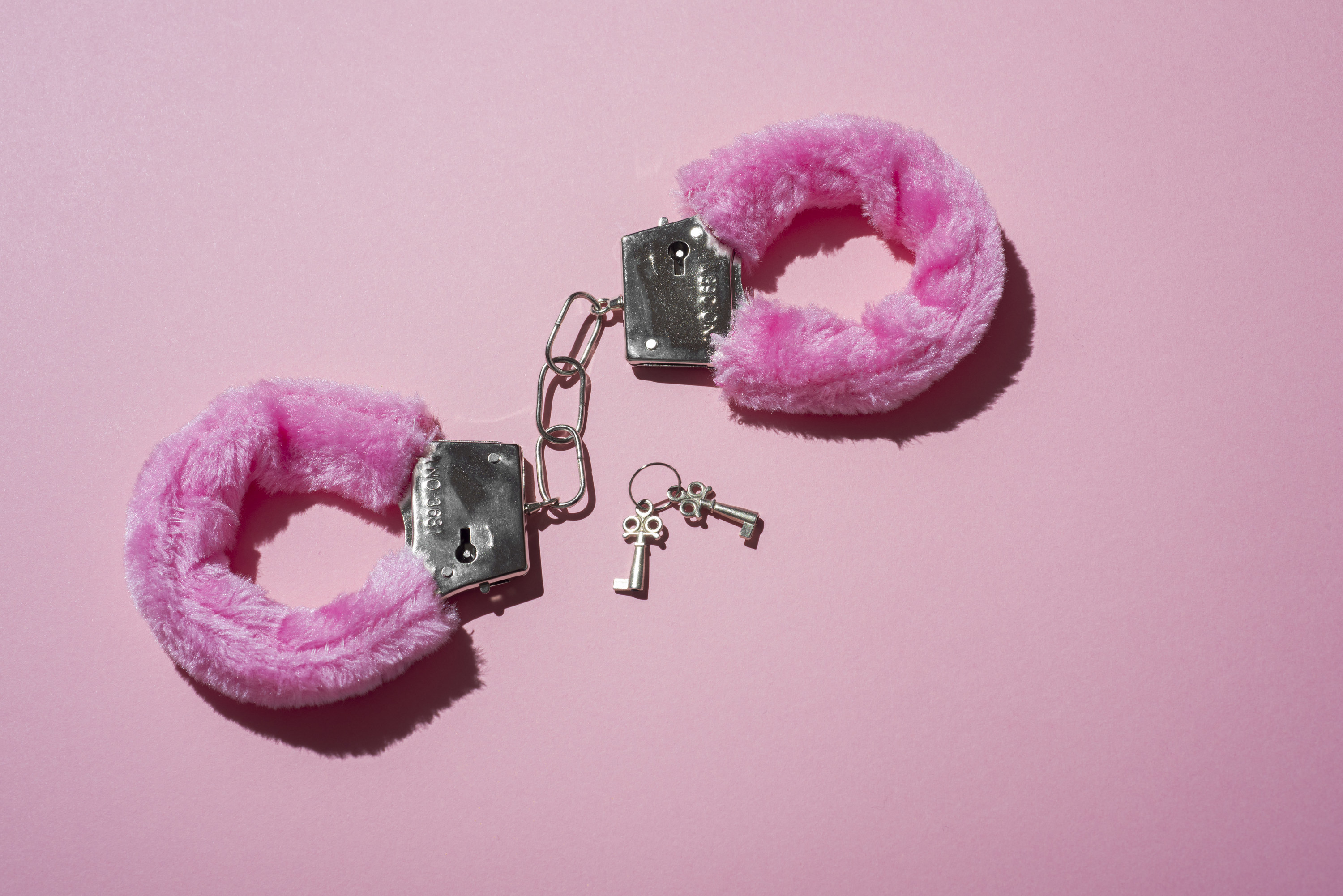 A stock image of pink, furry handcuffs