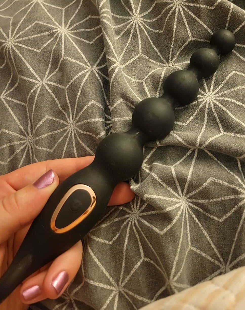 reviewer holding black beaded anal plug