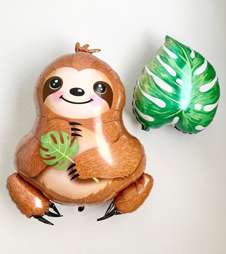 balloon shaped like a sloth holding a leaf and balloon shaped like monstera leaf
