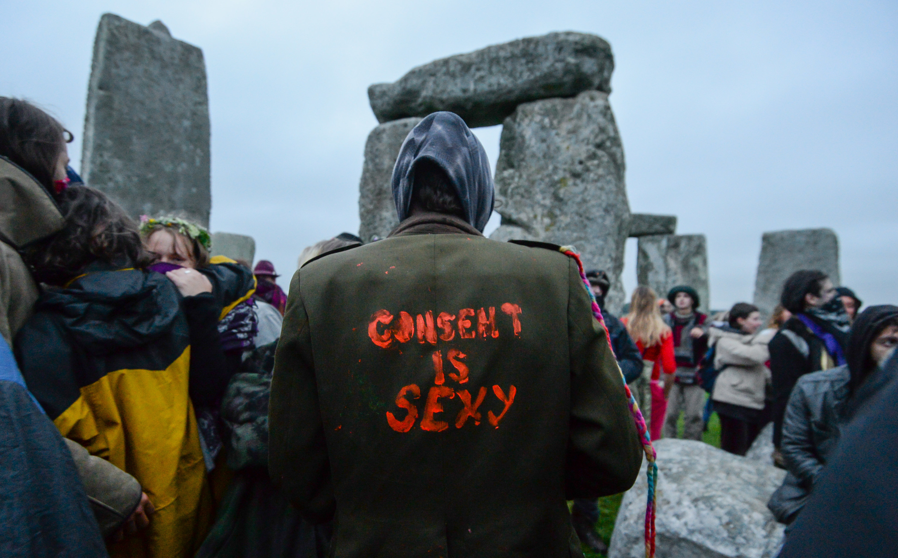 An image of the back of someone&#x27;s jacket with &quot;Consent is sexy&quot; painted on it in red paint