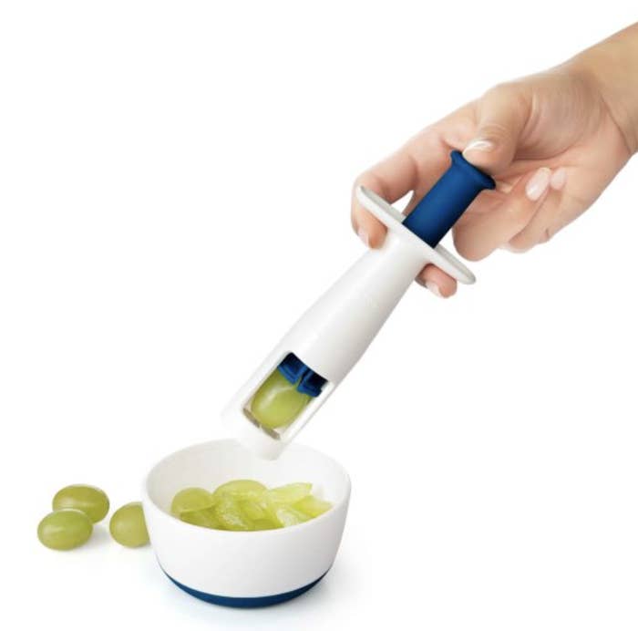 a model using a grape cutter to slice grapes into smaller pieces