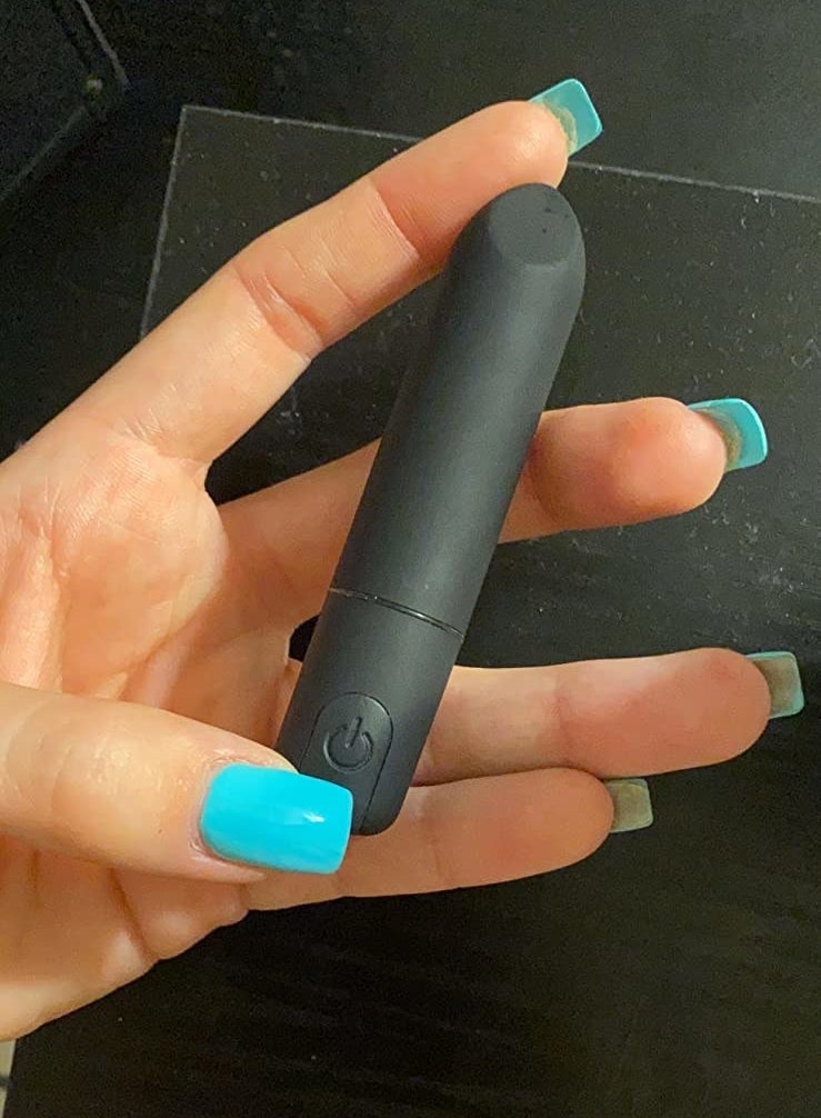reviewer holding black bullet vibrator
