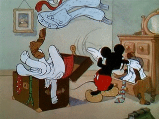 Mickey Mouse shoving clothes from a dresser into a suitcase