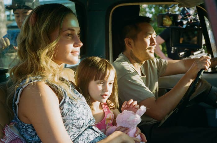 The family sitting inside a pickup truck, smiling
