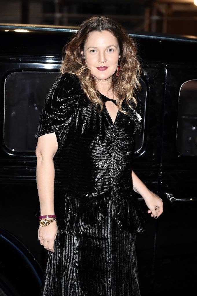 An adult Drew posing for photographers in a dark-colored dress