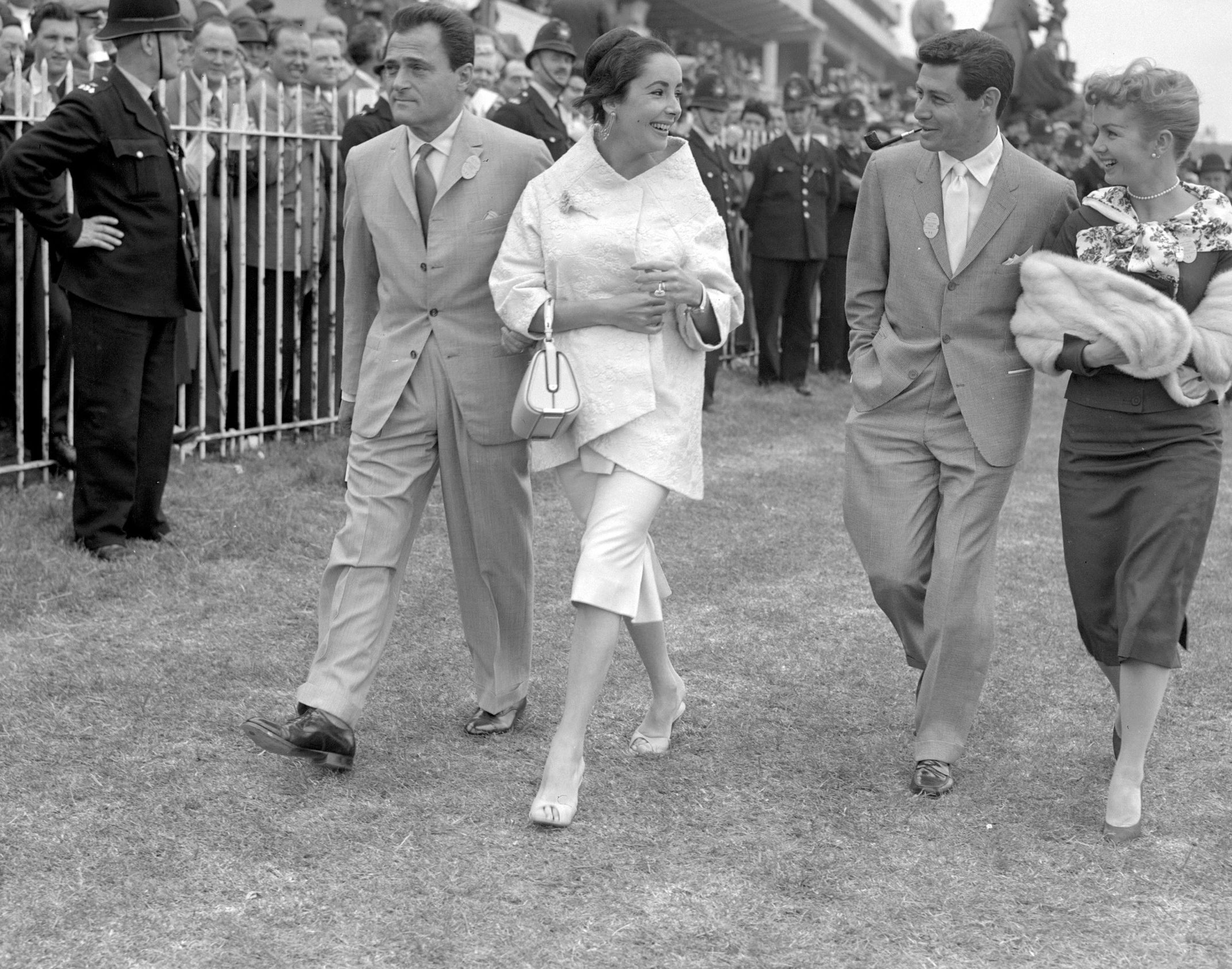 the two couples stroll together at a horse derby