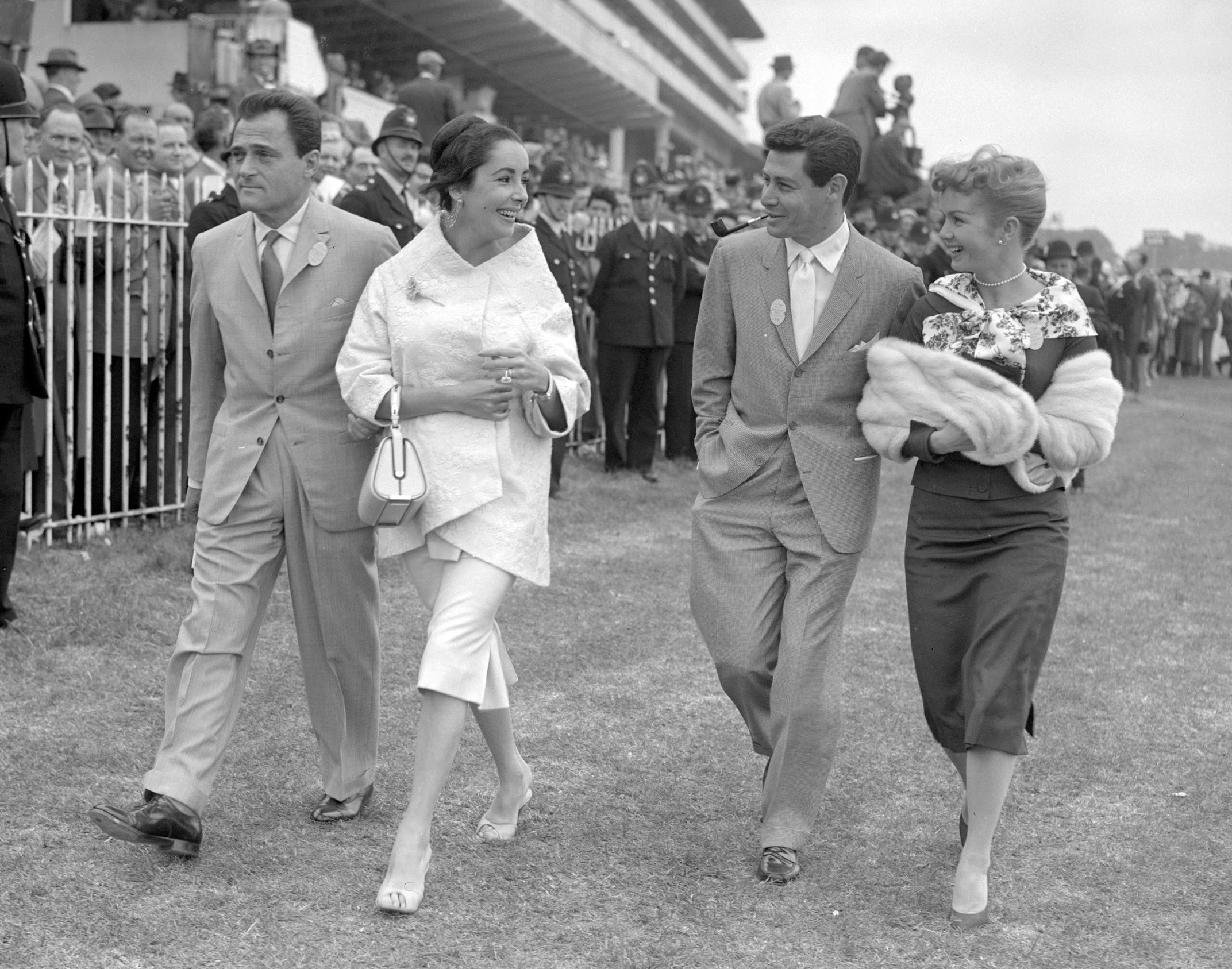 the two couples stroll together at a horse derby