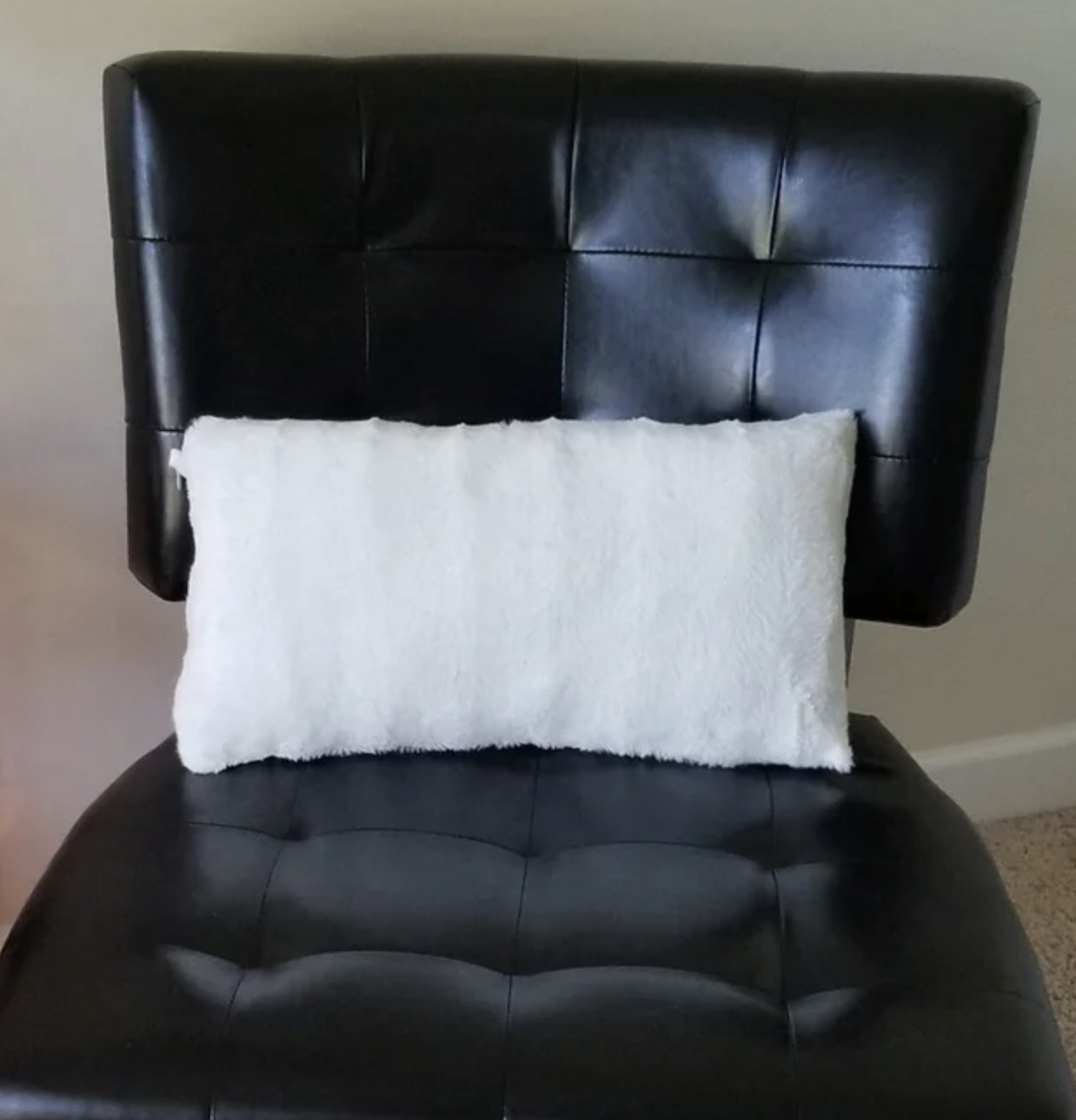 A reviewer photo of a white faux fur lumbar pillow