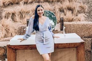 reviewer wearing a grey off shoulder dress