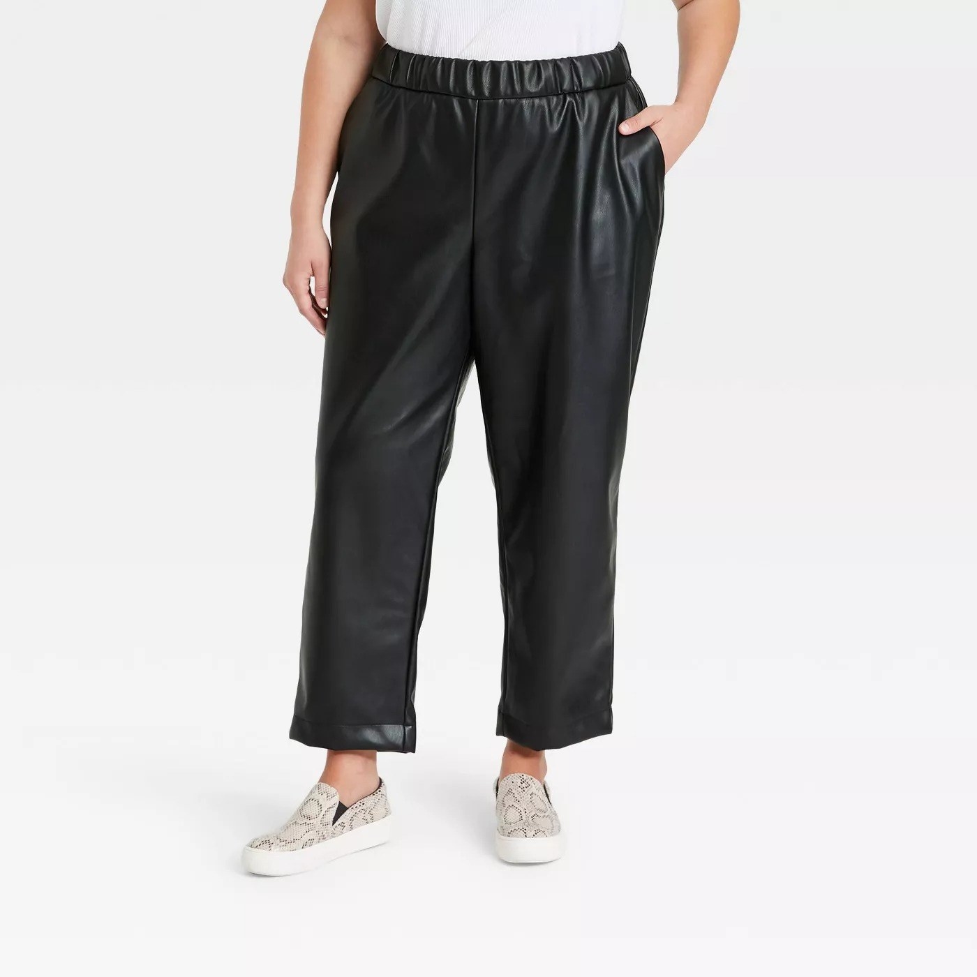 Model wearing black pleather pants, goes past the ankle