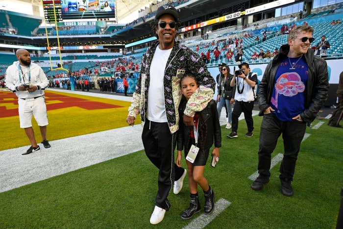 Blue walking on the football field with Jay-Z before the Super Bowl