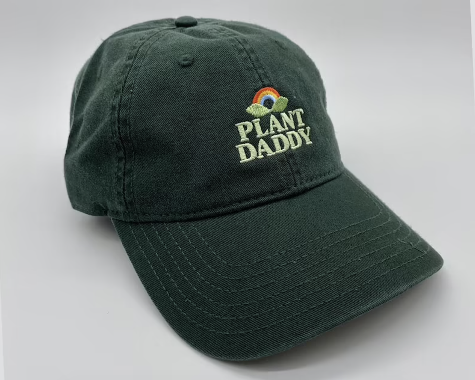 A dark green hat says &quot;plant daddy&quot; on it