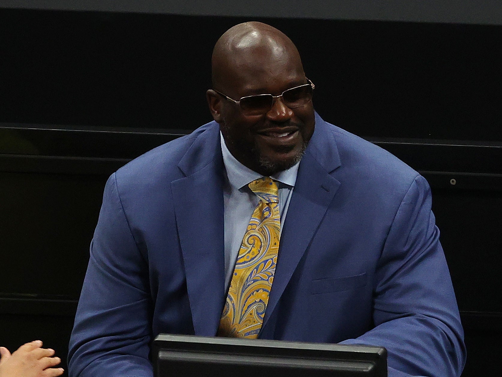 Shaq wearing a suit with sunglasses on smiling