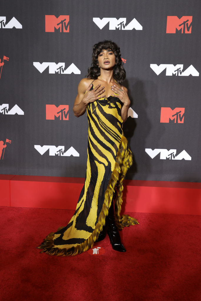 Bretman posing in a striped gown and boots