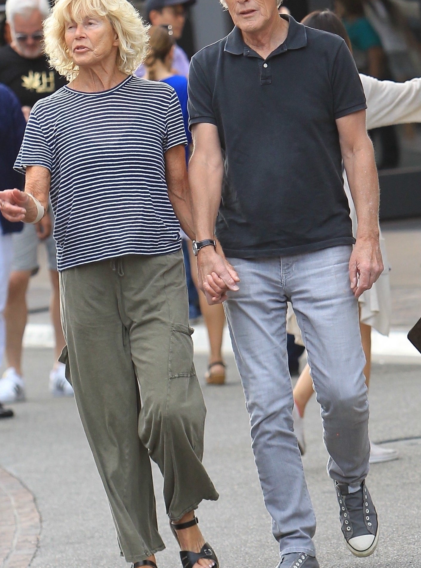 Suzanne and Keith holding hands and walking together, dressed casually
