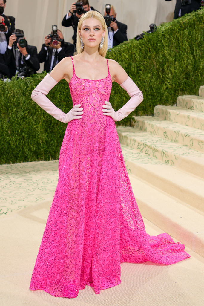 Nicola Peltz attends The 2021 Met Gala in a long brightly colored dress with matching long gloves