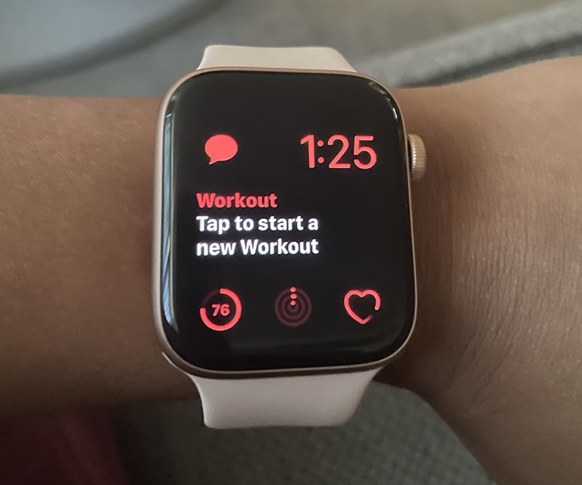 reviewer wearing the watch with a message on the screen that says tap to start new workout