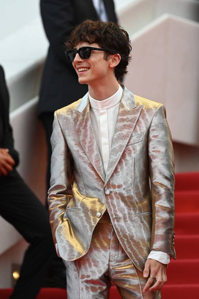 Timothée wearing a metallic suit and sunglasses at an event