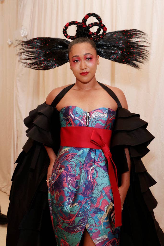 Naomi Osaka attends The 2021 Met Gala in a printed strapless dress with a matching cape and bow at the waist