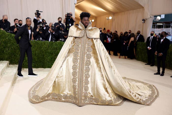 Lil Nas X  wears a floor length patterned cape
