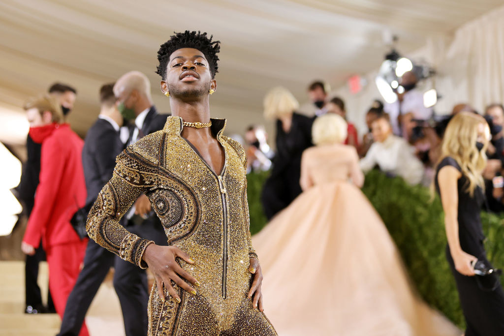 A close up of Lil Nas X as he poses in his glittery jumpsuit