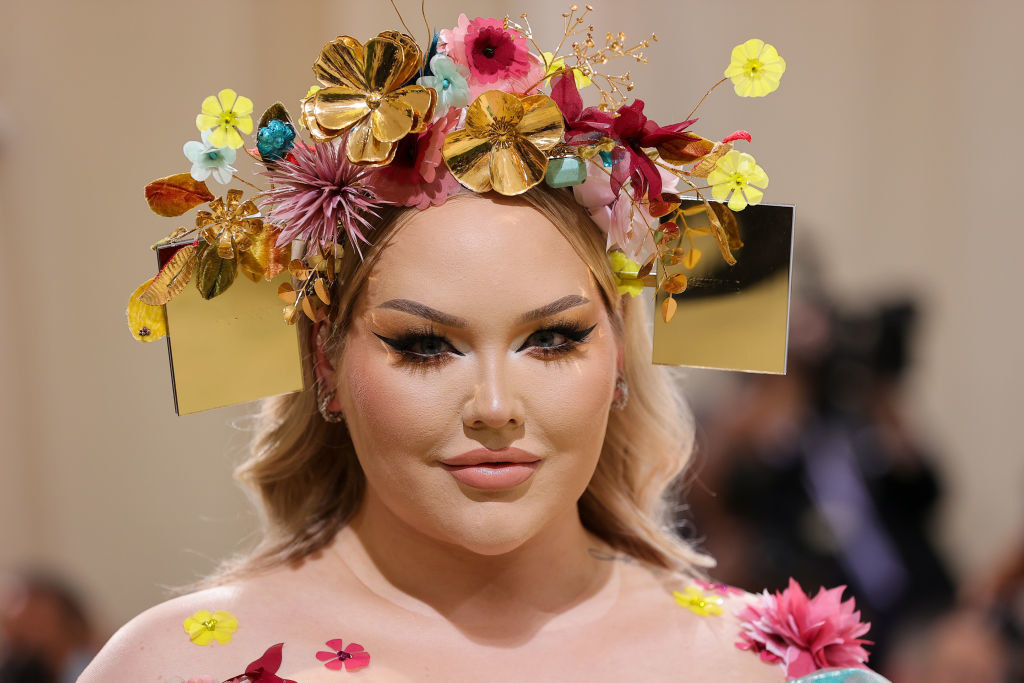 A close up of Nikkie de Jage shows off her floral head dress