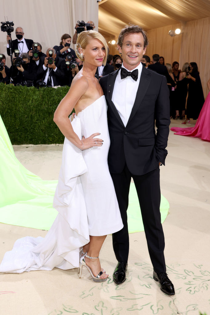 Claire Danes wears a floor length light colored strapless gown and Hugh Dancy wears a dark suit
