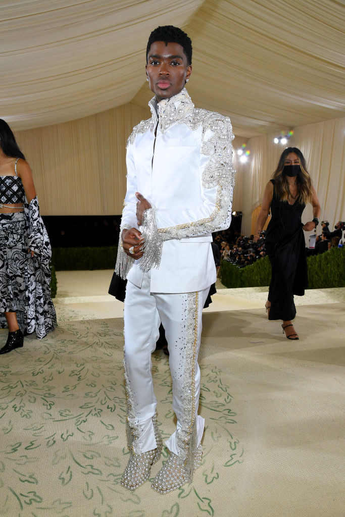 Alton Mason wears a matching light colored suit jacket and pants with bedazzled fringe on both