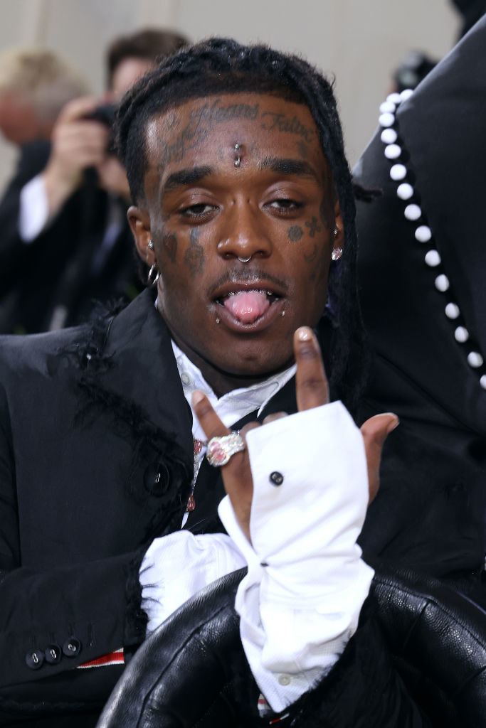 A close up of Lil Uzi Vert as he throws up the &quot;hang loose&quot; sign with his hand and sticks his tongue out