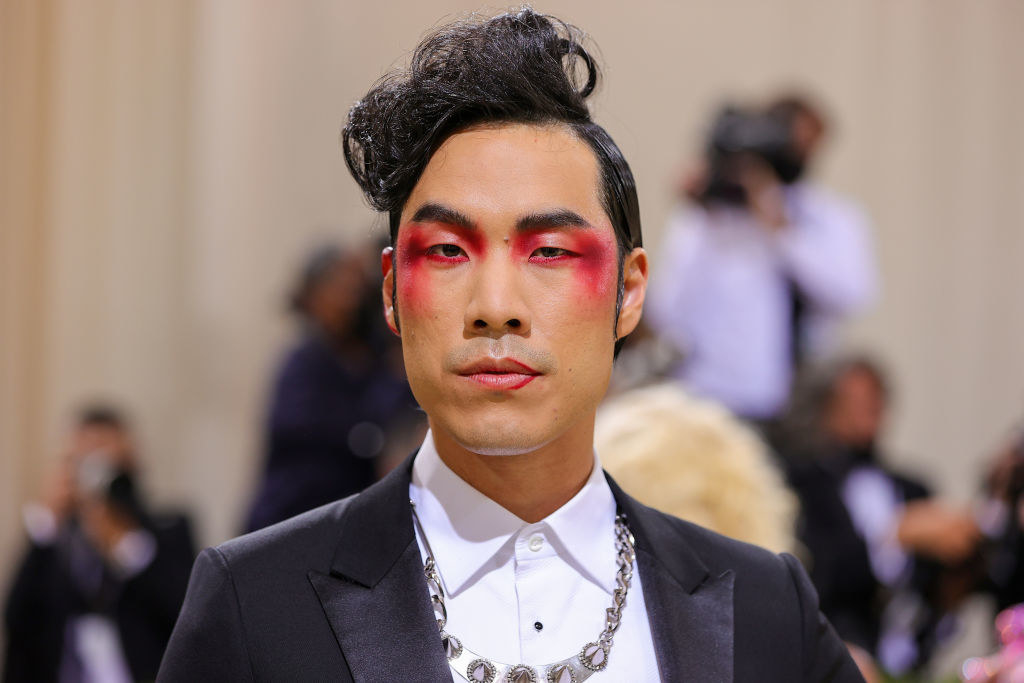 A close up of Eugene Lee Yang as he shows off his colorful eye makeup