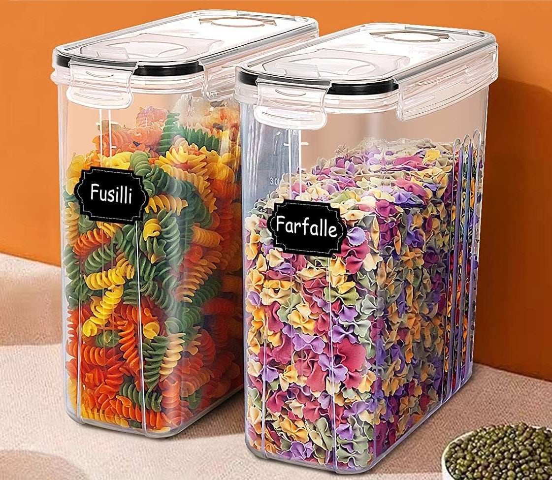 A pair of transparent plastic food storage bins filled with colourful pasta