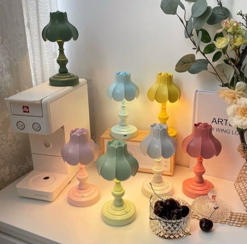 six pastel colored lamps on a white desk