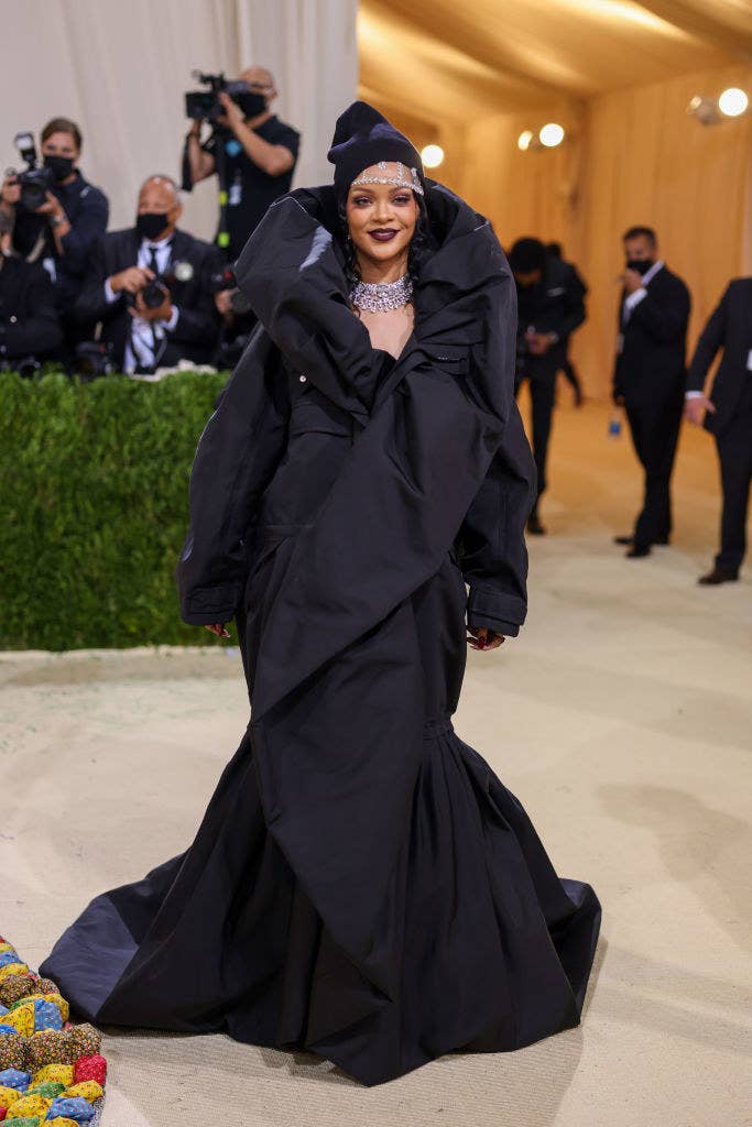 Rihanna wore a dark colored gown with a high collar and a beanie