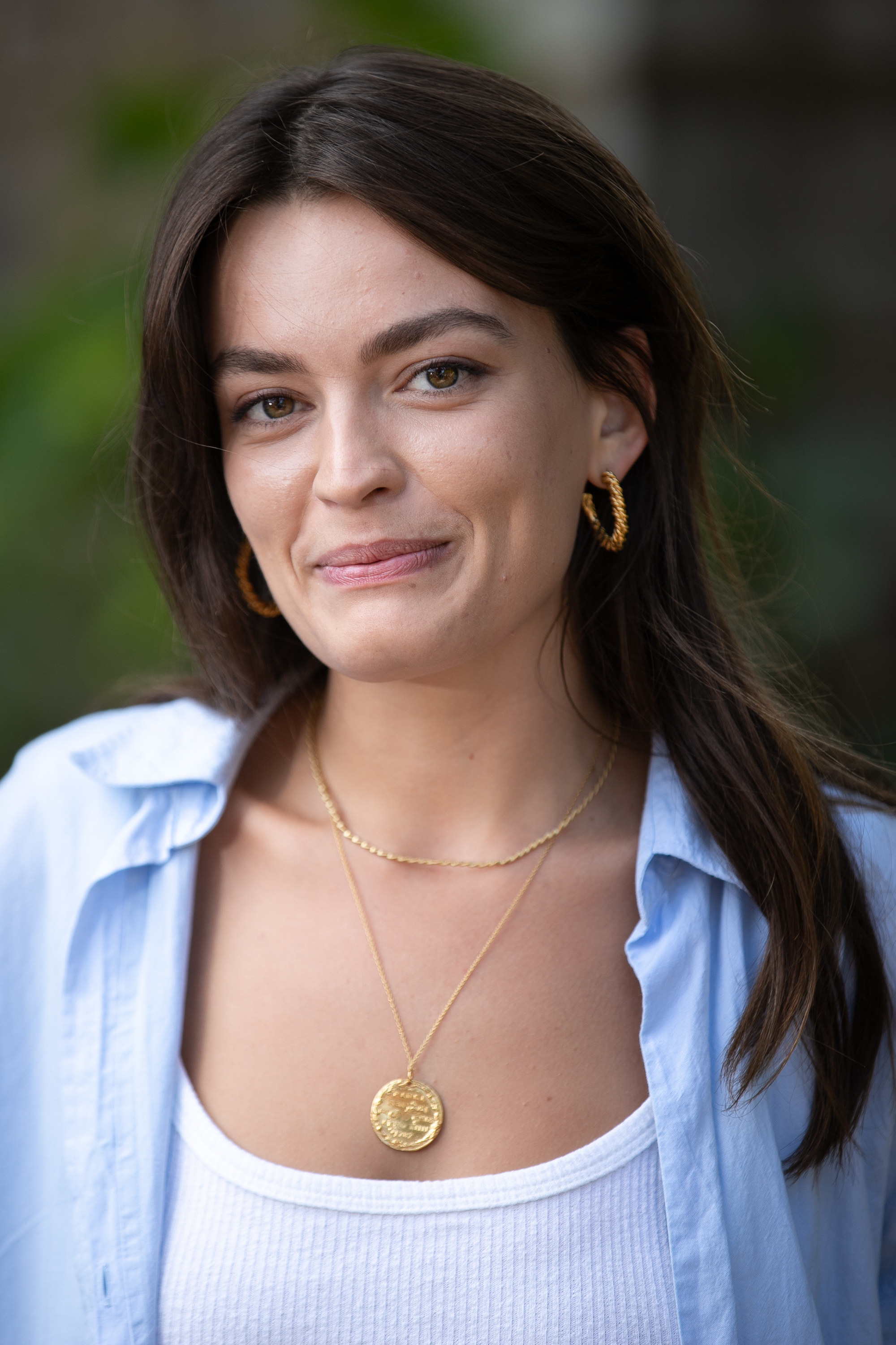 emma mackey posing in blue shirt as maeve wiley