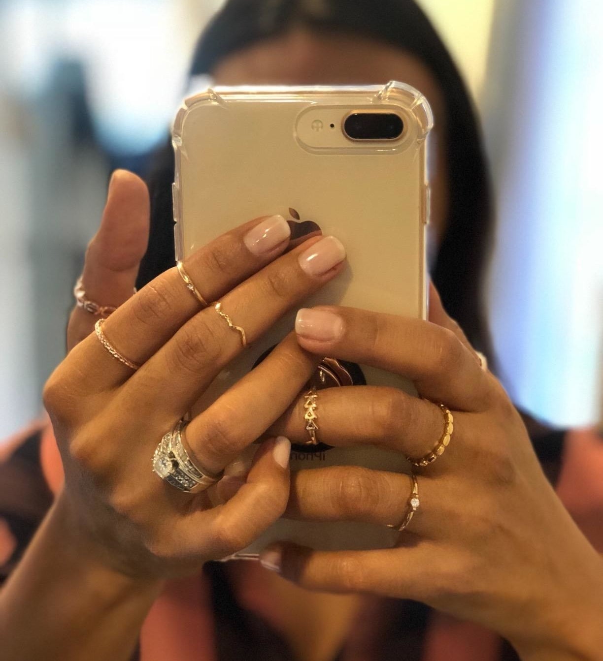 Reviewer is holding their camera up to a mirror to show off the stacked rings on their hands