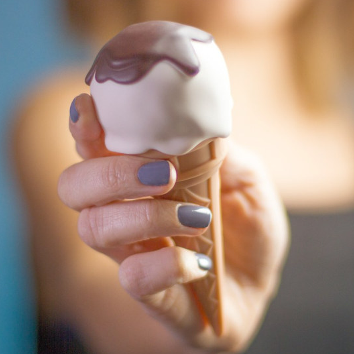 Model holding vanilla ice cream cone-shaped vibrator. 