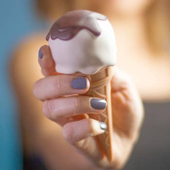Model holding vanilla ice cream cone-shaped vibrator