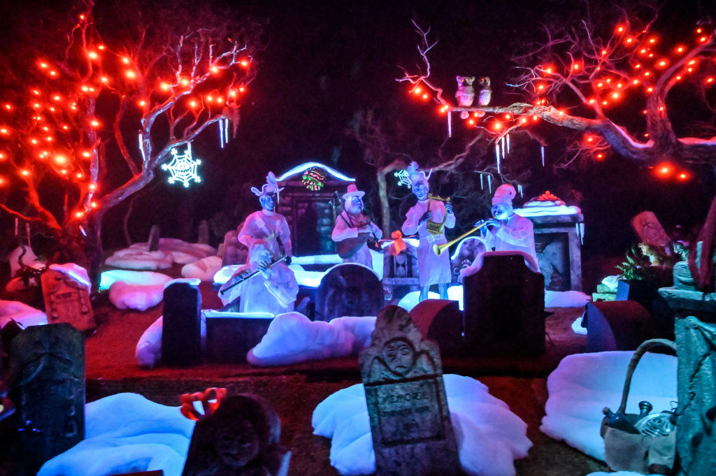 Inside the Haunted Mansion Holiday graveyard where ghost musicians play around graveyards, covered in fake snow
