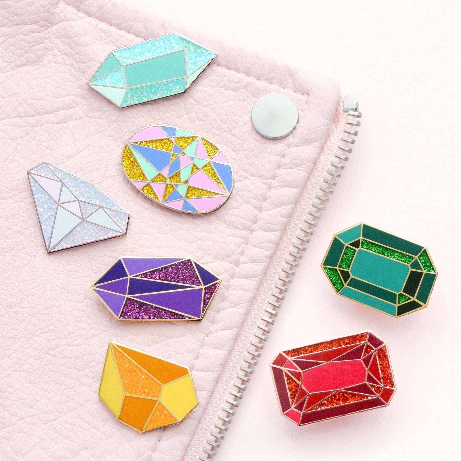 Seven enamel pins of various birthstones