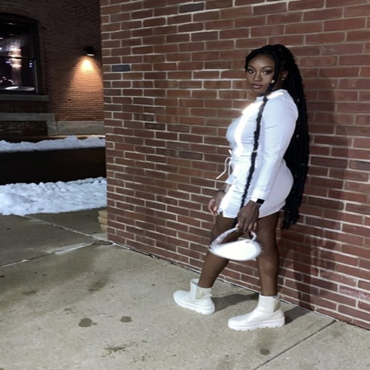 a reviewer wearing the white boots with a white dress 