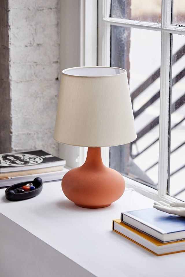 a ceramic table lamp with a white shade