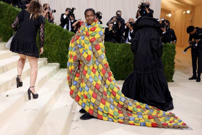 A$AP Rocky stands on the Met Steps with a multicolored quilt wrapped around him