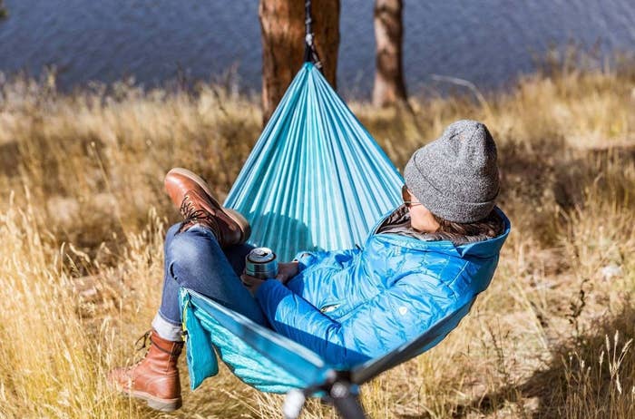 a girl sitting in a hammock hanging from a tree