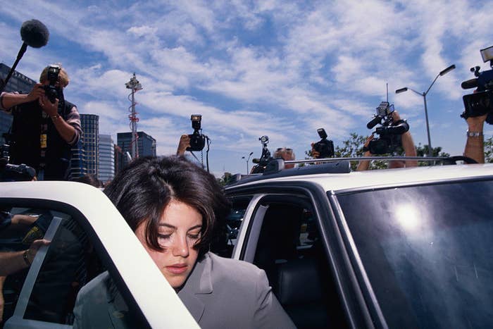 Monica Lewinsky getting into her car, surrounded by photographers